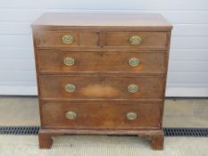 A late Georgian oak chest of two short over three long drawers having bracket feet,