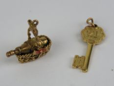 Two 9ct gold charms being a champagne bottle in basket and a '21' key, each hallmarked.