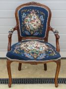 A delightful over-stuffed needlepoint decorated open-arm chair , shaped and carved throughout.