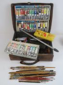 A pigskin leather case containing a quantity of vintage oil paints and painting ephemera,