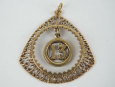 A 9ct gold '13' charm suspended within triangular bark effect pendant,