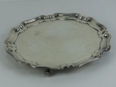 A HM silver salver having pie crust edge and raised over four scroll feet,