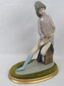 A Nao figurine of a seated girl with artists board and paintbrush (brush has come loose), 35cm high.