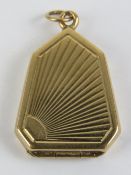 An unusual 9ct gold locket being a heptagon with engraved sunrise design to front, hallmarked 375,