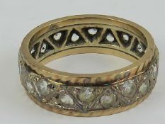A 9ct gold eternity ring having geometric triangular pattern set with white stones, hallmarked 375,