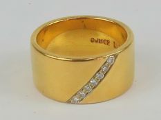 A wide 22ct gold ring having diagonal set row of seven diamonds, hallmarked 22ct gold Birmingham,