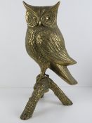 A large life size cast brass owl upon a triform branch, 46cm high.