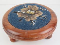 A good contemporary heavy circular mahogany footstool with needlepoint decoration to centre,