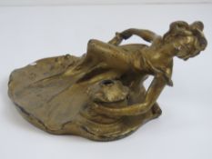 A gilded spelter Art Nouveau inkwell in the form of a recumbent female, 20cm wide,