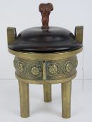 An Oriental late 19th / early 20th century brass censor raised over three tapering legs,