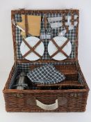 A wicker picnic hamper in unused condition complete with thermos, champagne glasses, cruet, cutlery,