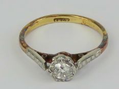 An 18ct gold and diamond solitaire ring, the round cut diamond in illusion setting of white metal,
