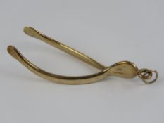 A large 9ct gold pendant in the form of a wishbone, approx 6.