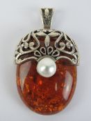 A large Baltic amber and silver pendant, stamped 925, 5.4cm in length inc bale.