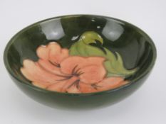 Moorcroft; a 'Hibiscus' pattern pin or trinket dish, salmon coloured flower on a green background,