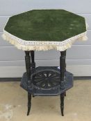 An ebonised octagonal table raised over