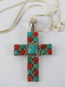 A silver crucifix set with faux coral an