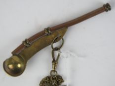 A copper and brass Bosons whistle on guard chain.
