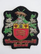 A gilt and silvered thread embroidered cloth insignia 'non progredi est regredi' (to not go forward