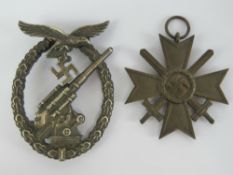 A WWII German crossed swords medal together with a WWII German badge (pin a/f). Two items.