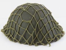 A WWII British 'tortoiseshell' helmet with netting, liner and strap.