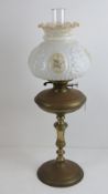A Victorian oil lamp having brass base and reservoir, milk glass shade and chimney, 68cm high.