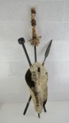 An African animal skin shield with spear, cane and club, 126cm high.