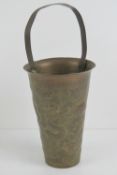 An Oriental brass brush pot having handle over, embossed four toed Dragon and foliage upon,