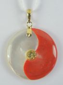 A 24ct gold mother of pearl and red jade disc pendant, bale stamped 24k, 2.5cm dia.
