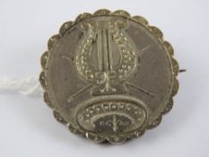 A late Victorian silver mourning brooch having glazed panel to back and applied lyre detail to