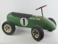 A vintage green painted childs ride on 'Racing Team' car, 71cm in length.