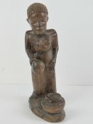 An African rosewood carving depicting a female with cooking pot,