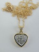 A 9ct gold pendant having central white metal heart set with diamonds, yellow metal surround,