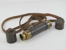 A brass and leather clad three drawer monocular having end caps and strap, 40.5cm extended.