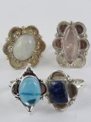 Four hardstone rings each stamped 925, size S-T, including moonstone and lapis lazuli.