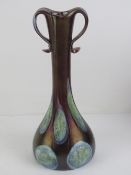 A handmade Czech glass lustre vase in purple ground with top loop handles, standing 27cm high.