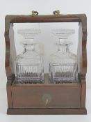 A tantalus having pair of decanters with original stoppers and complete with key,