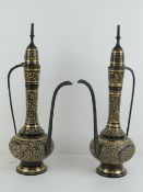 A pair of brass and black ground Arabic coffee pots.