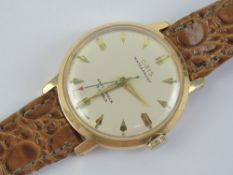 An Oris manual wristwatch on leather strap, cream dial with yellow metal hands.