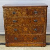 A faux walnut chest of two short ofver three long drawers having brass escutcheon plates and drop