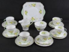 A Shelley Tea Service in Primrose pattern, comprising jug, sugar bowl, cake plate, and six trios.