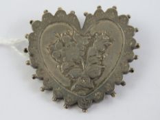 A late Victorian silver heart shaped mourning brooch having applied floral decoration,