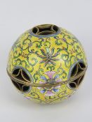 A Chinese Canton enamel on brass hand warmer, having yellow ground with floral decoration upon,