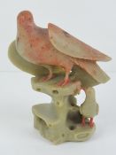 An Oriental soapstone dove figurine standing 13cm high.