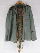 A reproduction WWII German dot camouflage SS jacket and trousers with Infantry Assault badge.