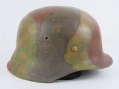 A WWII German M42 camouflage helmet with liner and chin strap, marked within 2407 ET-66.