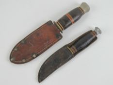 A William Rodgers Sheffield hunting knife having 7cm blade with leather scabbard/frog.