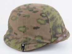 A German helmet with SS camo cover, stamped within 390 SE 68, further marked Pz.Div. NRCH.