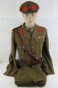A WWII British Army Brigadiers uniform having brass buttons and badges upon,