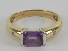 A 9ct gold Amethyst and diamond ring, the central emerald cut amethyst approx 0.